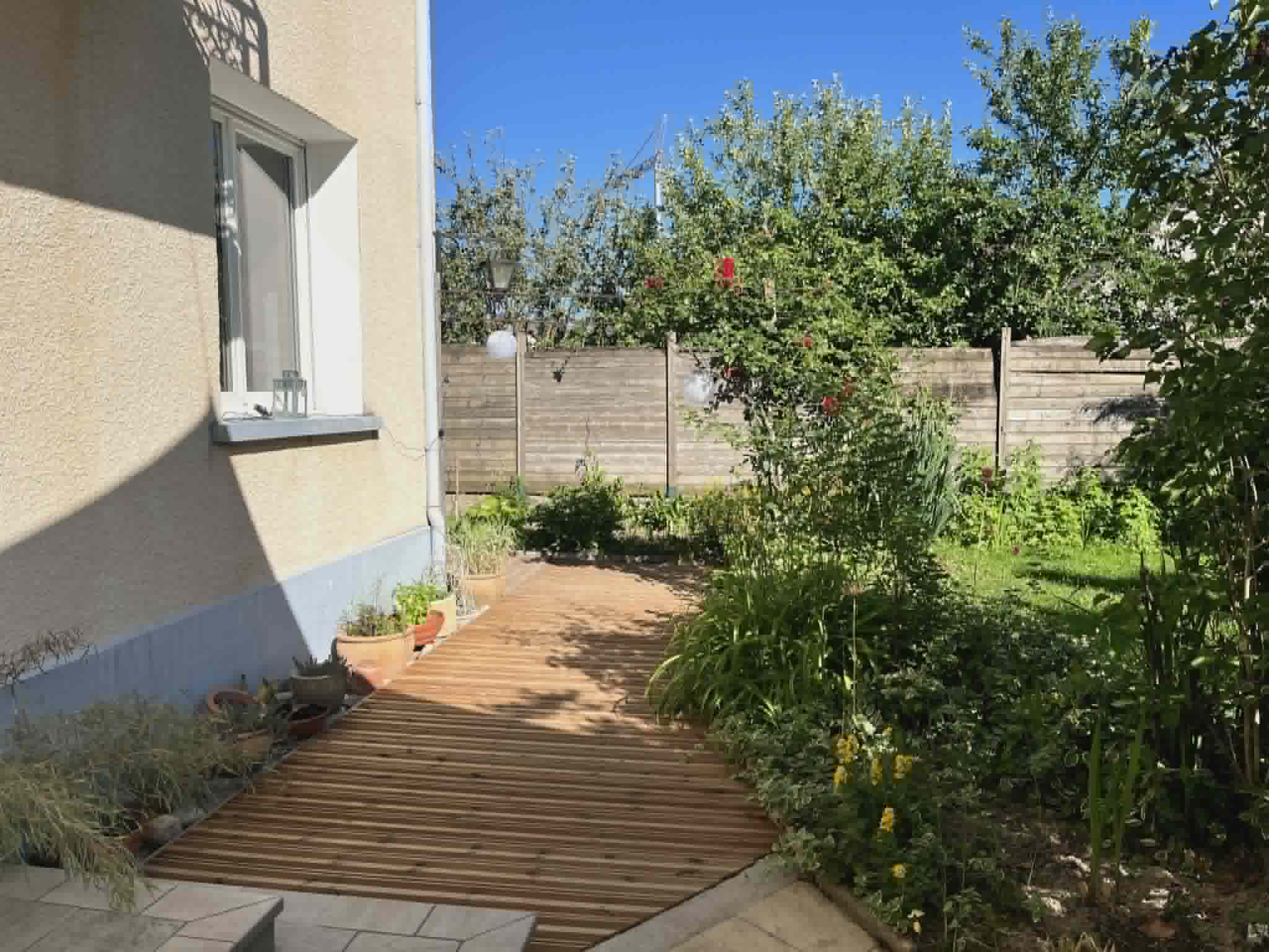 Allée en bois menant au salon à travers le jardin